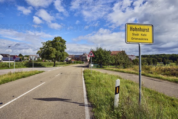 Town entrance sign, general development, building, road, guide post, trees, grass, forest, blue sky, cumulus clouds, district road K5329, Hanauerlandstraße, district of Hohnhurst, Kehl, Upper Rhine Plain, Ortenaukreis, Baden-Württemberg, Germany