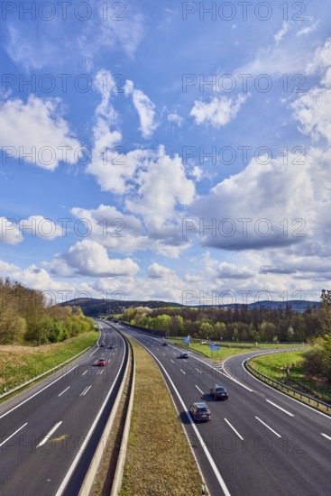 Hilly landscape, motorway exit AS Bessenbach Waldaschaff, lanes, guide post, guardrail, medium green, forest, blue partly cloudy sky, cumulus clouds, cumulus congestus clouds, vehicles, A3 motorway, Bessenbach, Lower Franconia, Aschaffenburg district, Bavaria, Germany