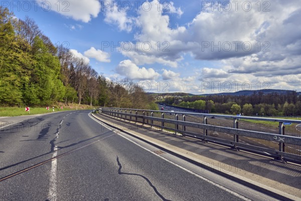 Road, curve, guide post, guardrail, center line, car bridges, metal railings, highway, hilly landscape, hills, forest, trees, grass, partly cloudy blue sky, cumulus clouds, cumulus congestus clouds, motorway bridge over A3, Bessenbach, Lower Franconia, Aschaffenburg district, Bavaria, Germany