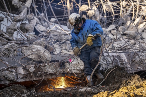Workers with cutting torches demolishing the 120-meter long motorway bridge of the A516, across Teutoburger Straße in Oberhausen-Sterkrade, the bridge, built in 1970 was severely damaged, traffic continues to roll on the remaining west bridge, after demolition, the eastern part is rebuilt using a process that is unique in the world to date, 40 meter long precast concrete beams are assembled one after the other, reducing construction time from 24 to 7 months, After the completion of this bridge, the western part will also be rebuilt, North Rhine-Westphalia, germany