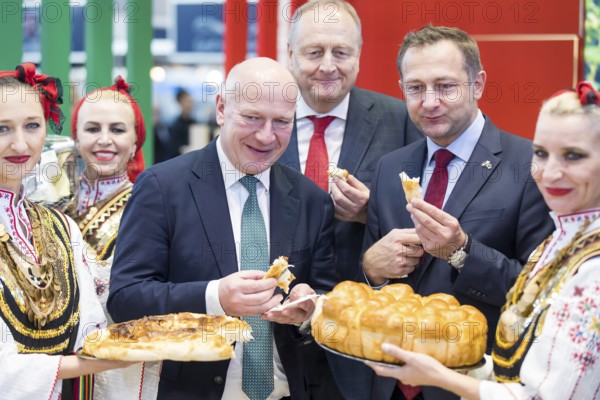 Kai Wegner (Governing Mayor of Berlin), Joachim Rukwied (President of the German Farmers' Association) and Christophe Hansen (Commissioner for Agriculture and Rural Development) at a bread tasting at the Bulgarian stand during the opening tour of the Green Week at the exhibition grounds in Berlin on 16 January 2026. The trade fair for the agricultural and food industry will take place from 16 to 25 January 2026