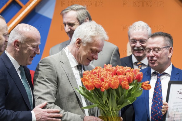 Alios Rainer (Federal Minister of Agriculture, Food and Home Affairs) smells a bouquet of tulips in the hall of the Netherlands during the opening tour of the Green Week at the exhibition grounds in Berlin on 16 January 2026. The trade fair for the agricultural and food industry will take place from 16-25 January 2026