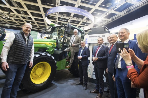 Alios Rainer (Federal Minister of Agriculture, Food and Home Affairs), Kai Wegner (Governing Mayor of Berlin), Christophe Hansen (Commissioner for Agriculture and Rural Development) and Joachim Rukwied (President of the German Farmers' Association) in front of an electric John Deere E-Power prototype tractor during the opening tour of the Green Week at the exhibition grounds in Berlin on 16 January 2026. The trade fair for the agricultural and food industry will take place from 16 to 25 January 2026