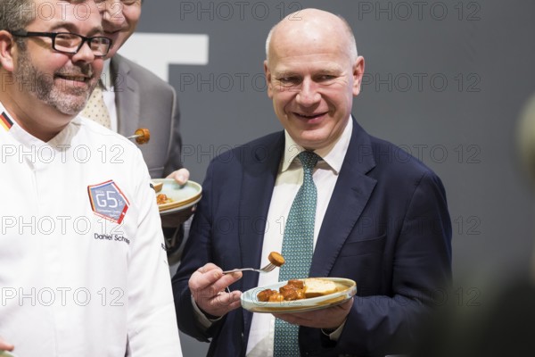 Kai Wegner (Governing Mayor of Berlin) tries a currywurst during the opening tour of the Green Week at the exhibition grounds in Berlin on 16 January 2026. The trade fair for the agricultural and food industry will take place from 16-25 January 2026