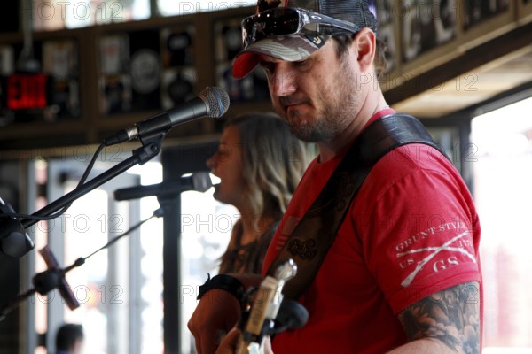 Musicians sing into microphones while playing acoustic guitar, rock atmosphere reigns, Nashville, Tennessee, USA