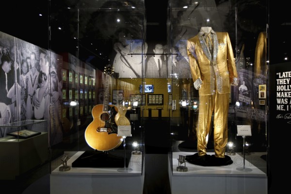 Golden clothing and an Elvis guitar on display in a museum, Memphis, Tennessee, USA