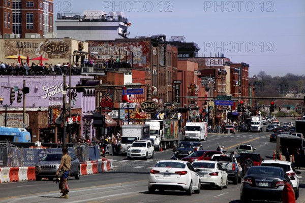 Traffic and pedestrians on Broadway Street in daylight, Nashville, Tennessee, USA