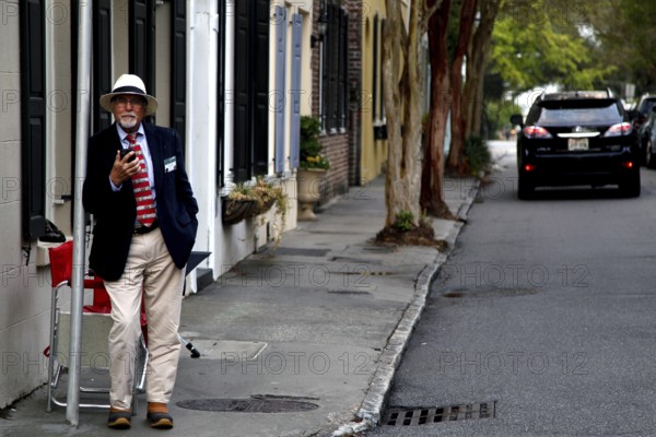 A walker on a street with historic antebellum houses, Charleston, South Carolina, USA