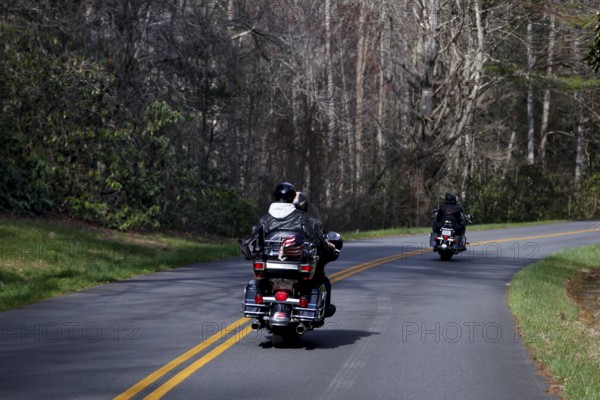 Motorcyclists ride on a winding road through wooded area, Blue Ridge Parkway, USA