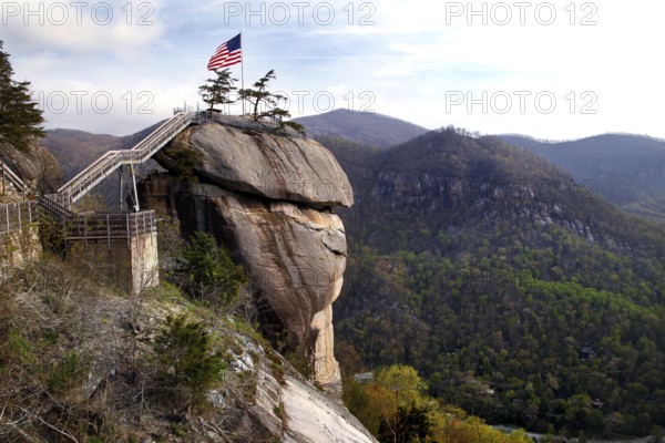 Chimney Rock with American flag and panoramic views of the forested mountains, zero