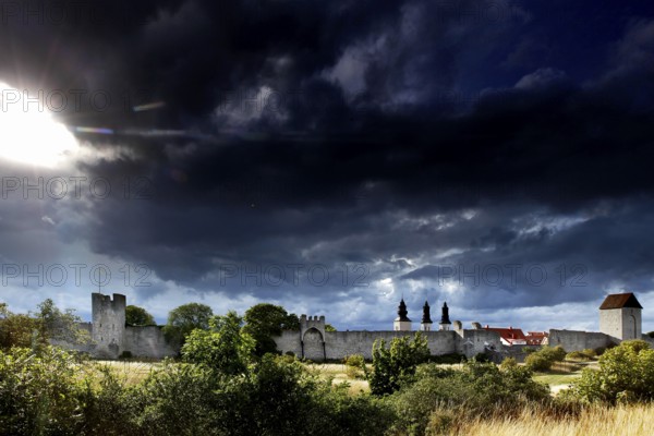 Visby city wall and cathedral towers against a dramatic sky, Visby, Gotland, Sweden