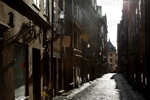 A shady old town alley in the historic old town of Stockholm, with paved paths and old buildings, Stockholm, Gamla Stan, Sweden