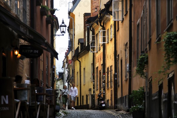 A lively old town alleyway in Stockholm, surrounded by colorful buildings and historic charm, Stockholm, Gamla Stan, Sweden