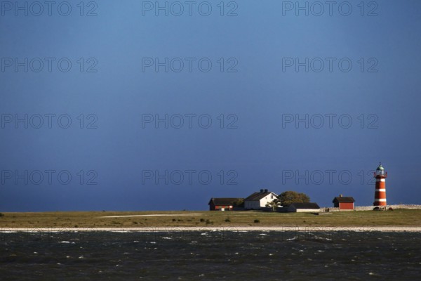 Lonely lighthouse on a quiet coastline under blue sky, Närsholmen, Gotland, Sweden