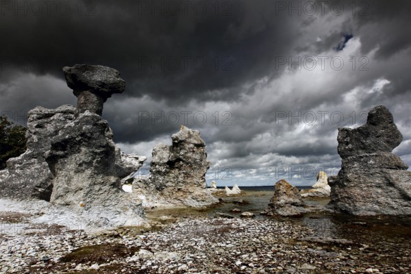 Impressive limestone pillars rise under dramatic clouds, Ljugarn, Gotland, Sweden