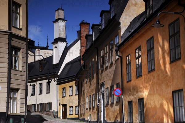 Colourful old town houses in Södermalm, Stockholm, with a church tower in the background, Stockholm, Södermanland, Sweden