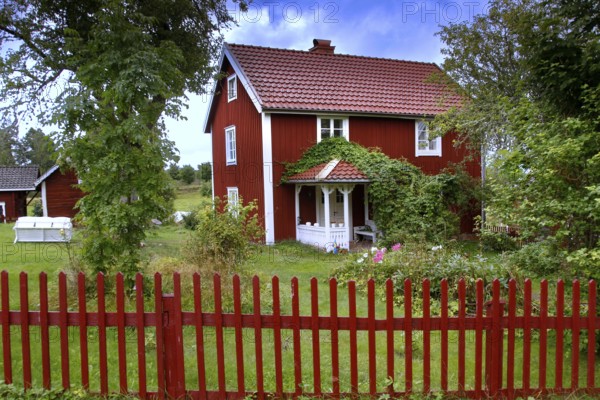 Red house surrounded by trees in an idyllic landscape, Svedstorp, Sweden