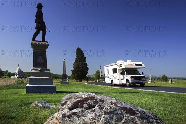A memorial stands in front of a motorhome in an open, green area of Gettysburg National Military Park, Gettysburg, Pennsylvania, USA