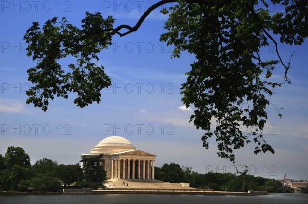 Large building with dome and pillars surrounded by water and trees, Washington D.C, USA