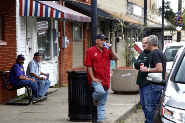 Men in casual clothes talk outside Fred's Lounge in Mamou, Mamou, Louisiana, USA