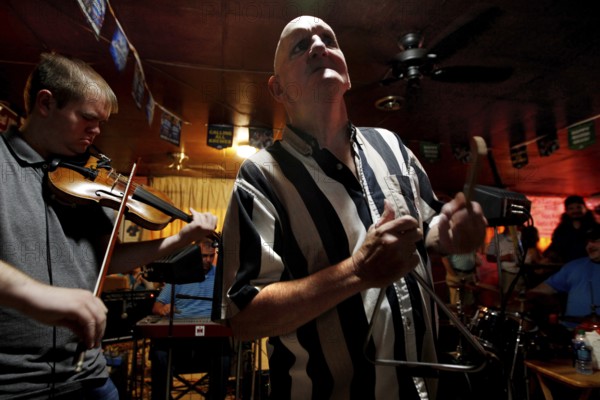 A triangle player performs with a violinist in the Cajun band, Mamou, Louisiana, USA