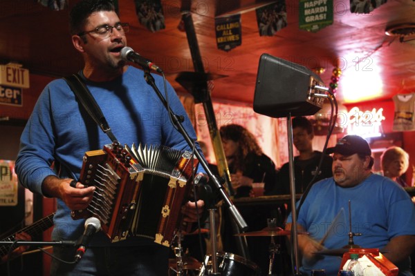 A harmonium player and singer perform in the Cajun band, Mamou, Louisiana, USA