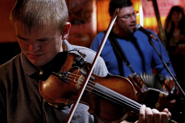 A violinist and singer perform in the Cajun band in Fred's Lounge, Mamou, Louisiana, USA