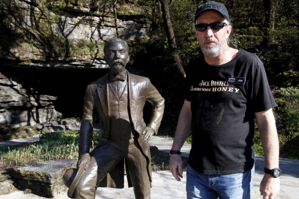 A bronze statue of Jack Daniel next to a man, Lynchburg, Tennessee, USA