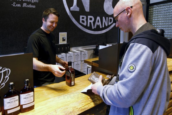 A man at the counter at Jack Daniel's Distillery receives a bottle, Lynchburg, Tennessee, USA