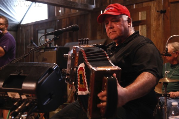 Accordion player on stage in the rustic setting of Randolph's Restaurant, Lafayette, Louisiana, USA