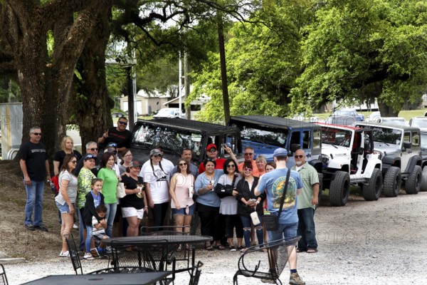 Group of visitors in front of vehicles at the McIlhenny Tabasco factory on Avery Island, Avery Island, Louisiana, USA