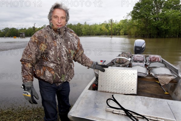 A man stands in a boat at the Atchafalaya Basin, ready for a tour in the wetlands, zero