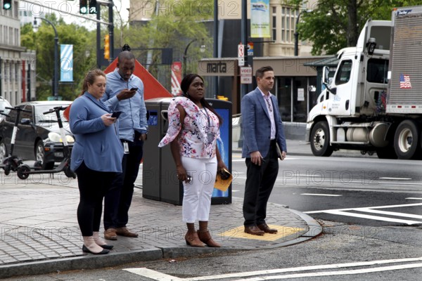 People wait at a pedestrian crossing in downtown Atlanta on Peachtree Street, Atlanta, USA