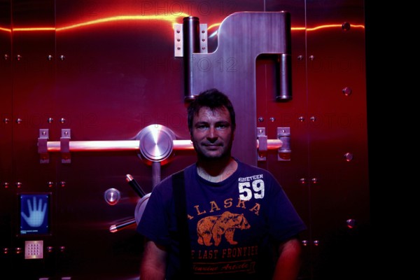 A man stands in front of a futuristic illuminated safe in the Coca-Cola Museum in Atlanta, Atlanta, Georgia, USA