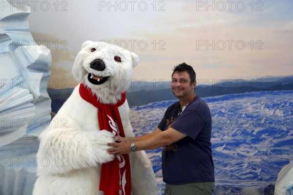 Person posing with Coca-Cola polar bear at the Coca-Cola Museum, cheerful atmosphere, Atlanta, Georgia, USA
