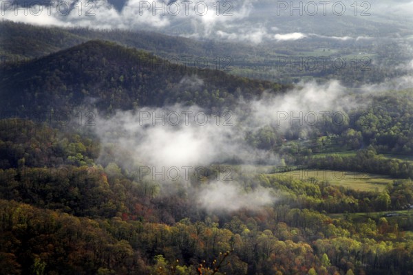 Fog sweeps through wooded hills and valleys
