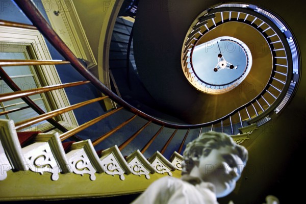 Spiral staircase with sculpture in a stylish interior, zero