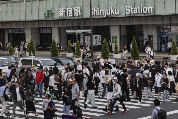 Passers-by cross the street in front of Shinjuku Station in Tokyo, Tokyo, Shinjuku, Japan