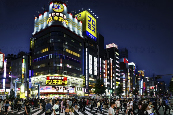 Busy night scene with neon lights and crowds, Tokyo, Shinjuku, Japan