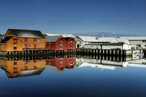 Warehouses are reflected in the calm water of the port of Vardø, Vardø, null, Norway