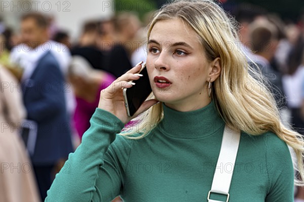 Young woman talking on the phone during a high school graduation ceremony on Cathedral Square, Vilnius, Vilnius County, Lithuania