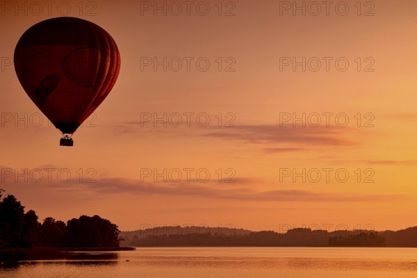 Hot air balloon at dusk over a still lake, Trakai, Vilniaus Apskritis, Lithuania