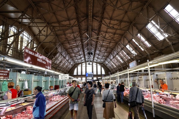 Interior view of bustling central market with historic structures, Riga, Latvia