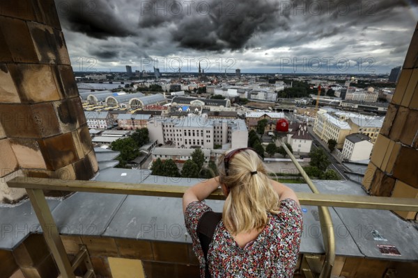 View from the Academy of Sciences over the city of Riga with a thoughtful woman in the foreground, Riga, Latvia, Latvia