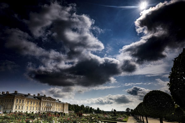 View of Ruhenthal Castle with dramatic sky and lush garden, Rundale, Latvia
