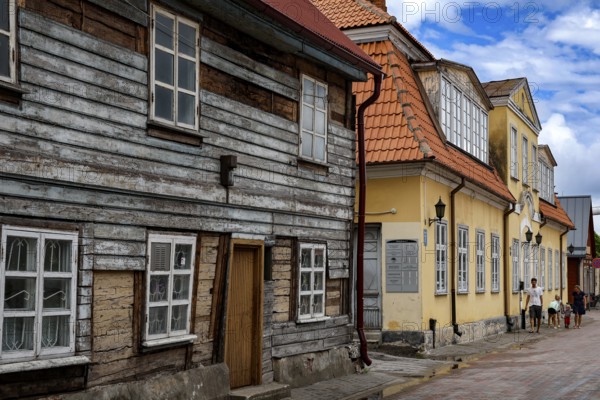 Charming old town alleyway with historic wooden houses and blue sky, Ventspils, Latvia