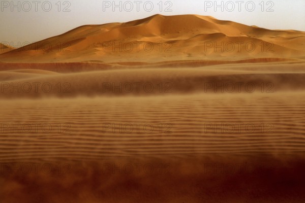 Dust envelops the sand dunes in the sprawling Erg Chebbi, Erg Chebbi, Morocco