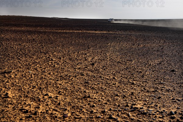 Endless expanse of dusty desert landscape under clear skies, Erg Chebbi, Morocco