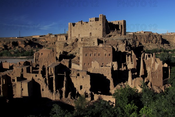 Clay kasbahs in a majestic desert backdrop under clear blue sky, El Kelâa m'Gouna, Valley of Roses, Morocco