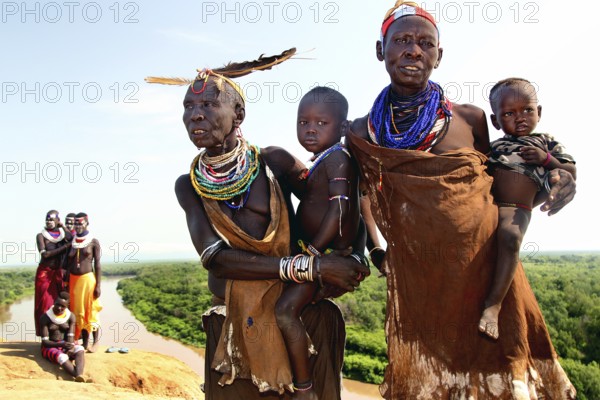 Two woman from Murle with babies and ornate necklaces, Murle, Ethiopia